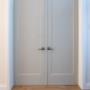 Two shaker doors painted gray with white casing and baseboard around them Two shaker doors painted gray with white casing and baseboard around them