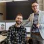 Two men in outsourced accounting division smiling at camera Two men in outsourced accounting division smiling at camera