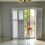 Vinyl Shutters with a Bi-Fold, Divider Rails, and Front Hinge Side Tilt-Bars on a Patio Door in an Aurora Home Vinyl Shutters with a Bi-Fold, Divider Rails, and Front Hinge Side Tilt-Bars on a Patio Door in an Aurora Home