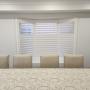 Framed Vinyl Shutters with Split-Tilt on a Dining Room Bay Window in a Richmond Hill Home Framed Vinyl Shutters with Split-Tilt on a Dining Room Bay Window in a Richmond Hill Home