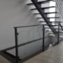 Escalier à limon central - Marches en merisier - Garde-corps ascendant en métal avec 4 tiges pleines horizontales et supports à verre 10 mm - Main courante tubulaire plate Escalier à limon central - Marches en merisier - Garde-corps ascendant en métal avec 4 tiges pleines horizontales et supports à verre 10 mm - Main courante tubulaire plate