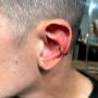 Conch Piercing avec une anneau en titanium noir. Conch Piercing avec une anneau en titanium noir.