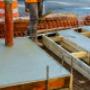 Construction worker leveling concrete pavement. Masonry construction workers smooth freshly poured concrete using bullfloat Construction worker leveling concrete pavement. Masonry construction workers smooth freshly poured concrete using bullfloat