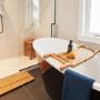 Installation luxueuse de salle de bain ARB Teak avec un pont de baignoire, un banc et un tapis de bain, rehaussant l'élégance d'une salle de bain carrelée en marbre. Installation luxueuse de salle de bain ARB Teak avec un pont de baignoire, un banc et un tapis de bain, rehaussant l'élégance d'une salle de bain carrelée en marbre.