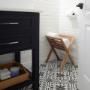Porte-serviettes ARB Teak élégant et meuble-lavabo moderne dans une salle de bain chic avec carrelage blanc et sol à motifs. Porte-serviettes ARB Teak élégant et meuble-lavabo moderne dans une salle de bain chic avec carrelage blanc et sol à motifs.