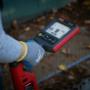 A close-up of a utility locator operator using advanced electromagnetic locating equipment. The handheld device features a digital screen displaying signal strength and directional indicators, helping to trace underground utility lines. A close-up of a utility locator operator using advanced electromagnetic locating equipment. The handheld device features a digital screen displaying signal strength and directional indicators, helping to trace underground utility lines.