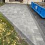 Modern interlock driveway installation with clean geometric pattern and dark border accents. Custom stone pavers enhance curb appeal for this residential home. Modern interlock driveway installation with clean geometric pattern and dark border accents. Custom stone pavers enhance curb appeal for this residential home.