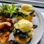 Vegetarian Eggs Benedict at Volta Victoria, topped with sautéed kale and mushrooms, served on toasted bread with poached eggs, creamy hollandaise sauce, crispy potatoes, and fresh greens — a hearty downtown Victoria brunch option. Vegetarian Eggs Benedict at Volta Victoria, topped with sautéed kale and mushrooms, served on toasted bread with poached eggs, creamy hollandaise sauce, crispy potatoes, and fresh greens — a hearty downtown Victoria brunch option.